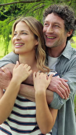 Smiling-couple-embracing-in-park