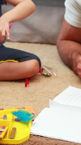 Happy-siblings-doing-arts-and-crafts-on-the-rug-with-parents