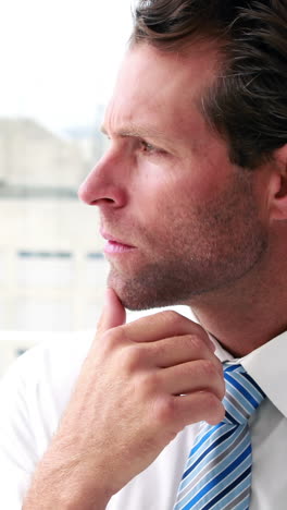 Handsome-businessman-thinking-and-looking-out-window