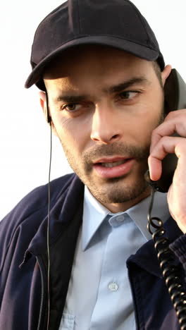 Security-guard-talking-on-phone-while-working-on-computer