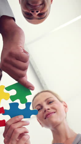 Business-colleagues-holding-pieces-of-puzzle