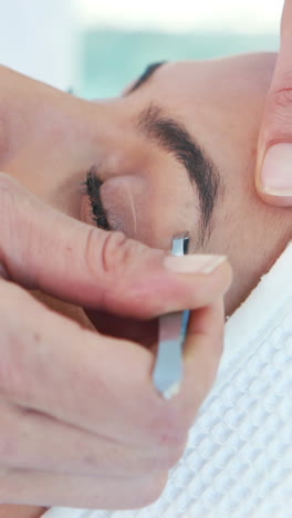 Woman-using-tweezers-on-patient-eyebrow