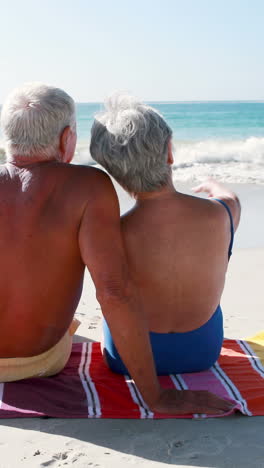 Retired-old-couple-lying-on-towel