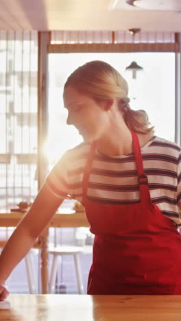 Waitress-wiping-table-at-counter