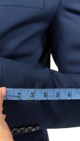 Hands-of-fashion-designer-taking-a-measurement-of-businessman