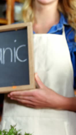 Female-staff-holding-organic-sign-board