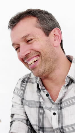 Smiling-man-reading-newspaper-while-sitting-on-the-couch