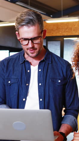 Business-people-discussing-over-laptop