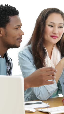 Partners-working-at-desk-using-laptop-and-computer