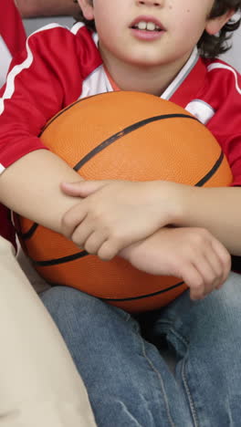 Familia-Sonriente-Con-Abuela-Viendo-Un-Partido-De-Baloncesto.