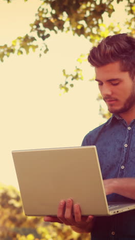 Hombre-Guapo-Usando-Laptop-En-El-Parque