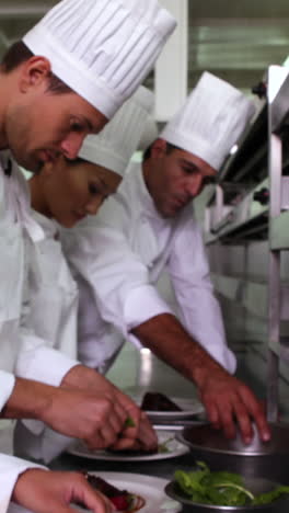 Row-of-chefs-garnishing-dessert