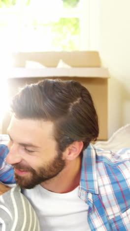 Cute-couple-sitting-against-a-cardboard-using-a-tablet