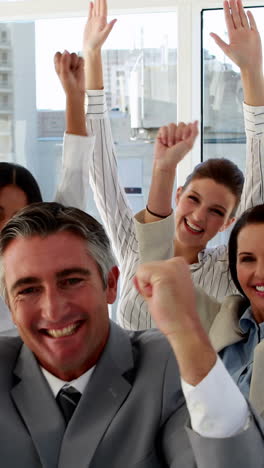 Excited-business-team-cheering-at-camera