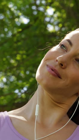 Runner-stretching-neck-listening-to-music-in-the-park