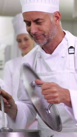 Jefe-De-Cocina-Degustando-Una-Olla-De-Sopa-Haciendo-El-Cartel-De-Ok