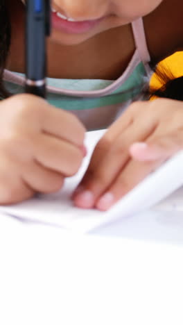 Schoolgirl-writing-on-chit-in-classroom