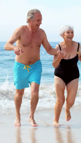 Happy-couple-running-on-sand