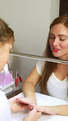 Nail-technician-and-customer-chatting-and-smiling