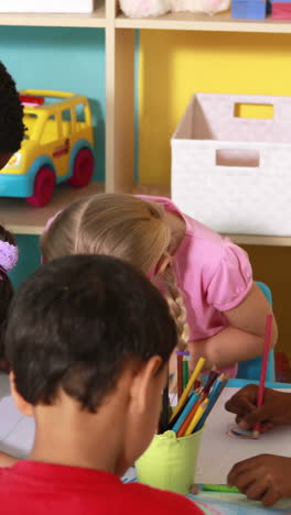 Preschool-class-drawing-at-table-in-classroom