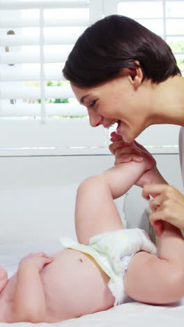 Happy-mother-playing-with-her-baby-on-a-bed