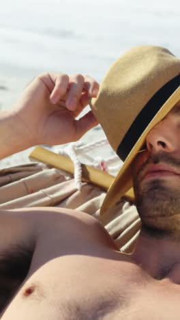 Man-wearing-hat-lying-in-hammock