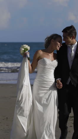 Feliz-Pareja-De-Recién-Casados-Caminando-Por-La-Playa