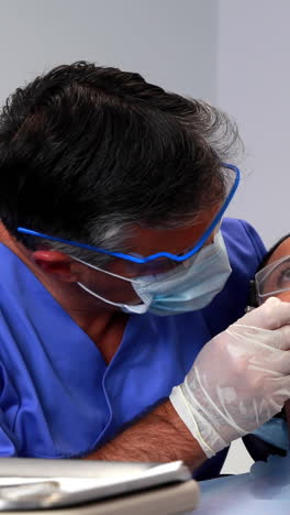 Dentista-Examinando-Los-Dientes-De-Un-Paciente-En-La-Silla-Del-Dentista