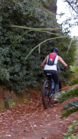 Female-cyclist-cycling-on-dirt-track