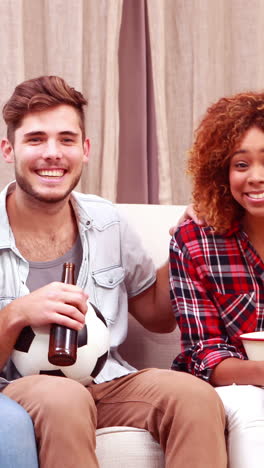 Amigos-Sonrientes-Viendo-Televisión-Mientras-Comen-Palomitas-De-Maíz-Y-Beben-Cerveza