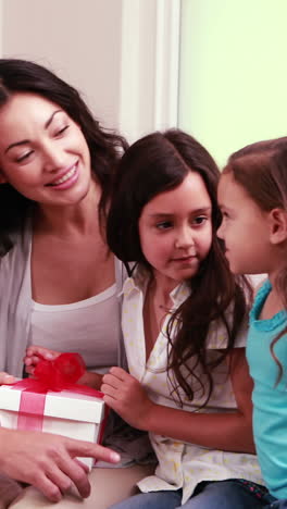 Girls-offering-gift-to-their-mother-