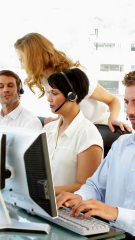 Supervisor-checking-on-call-centre-employees