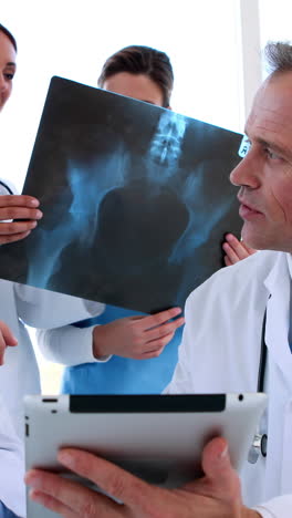 Medical-team-discussing-and-smiling-at-camera