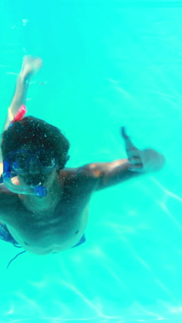 Man-in-snorkel-jumping-in-swimming-pool-waving-at-camera