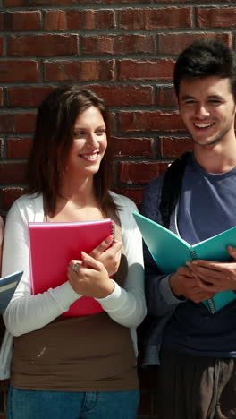 Happy-classmates-standing-and-studying-together--