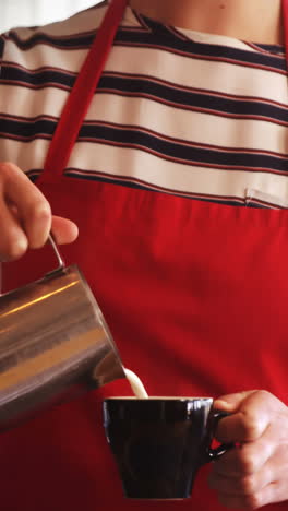 Waitress-making-cup-of-coffee-at-counter-in-cafÃ©