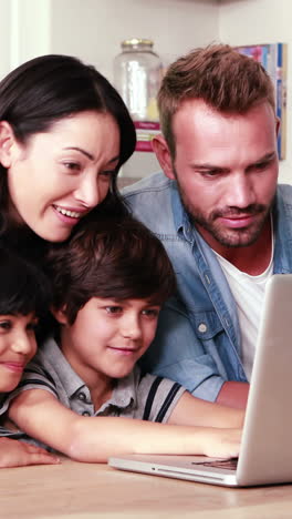 Familia-Sonriente-Usando-Laptop