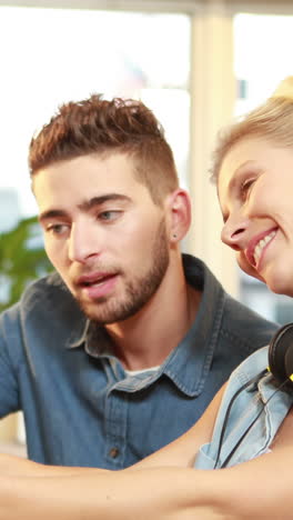 Smiling-casual-businesswoman-explaining-work-to-colleague