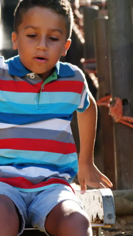 Schoolboy-sliding-on-slide-in-school-playground