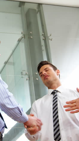 Businessmen-shaking-hands-in-office