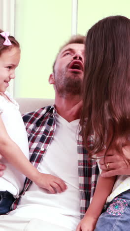 Happy-father-hugging-his-daughters-