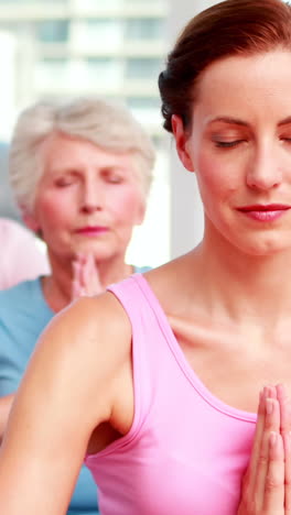 Group-of-peaceful-women-in-fitness-studio-doing-yoga