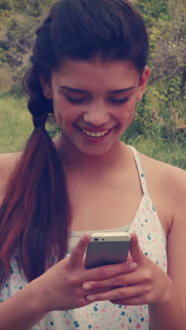 Pretty-brunette-texting-in-the-park