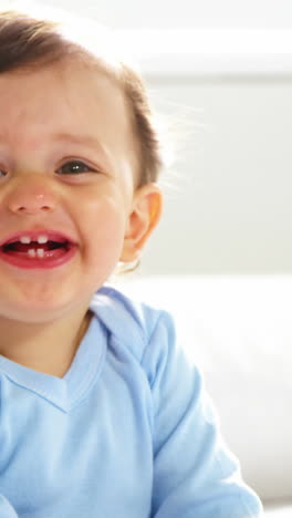 Lindo-Bebé-Con-Ropa-De-Dormir-Sonriendo-Y-Sentado-En-Una-Cama