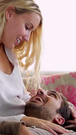 Man-lying-on-the-couch-with-head-on-girlfriends-lap