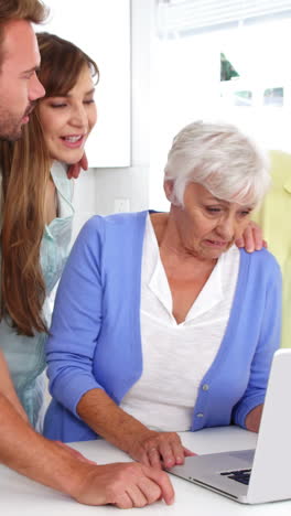 Zwei-Generationen-Lächeln-Und-Benutzen-Gemeinsam-Einen-Laptop