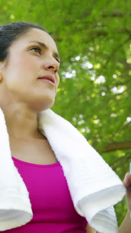 Frau-Wischt-Sich-Nach-Dem-Training-Im-Park-Die-Stirn-Und-Trinkt-Wasser