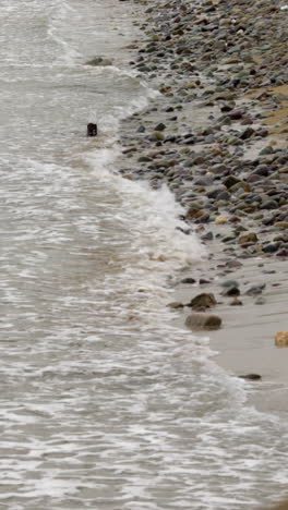 Sea-rolling-in-over-pebbly-beach