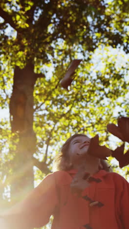 girl-throwing-leaves-in-park