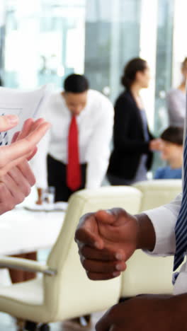 Businesspeople-shaking-hands-in-office